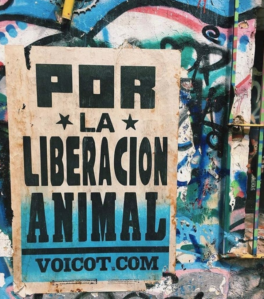 Photo of a sign that reads: "Por la liberacion animal. voicot.com"